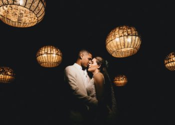 loving ethnic newlyweds hugging in dark studio