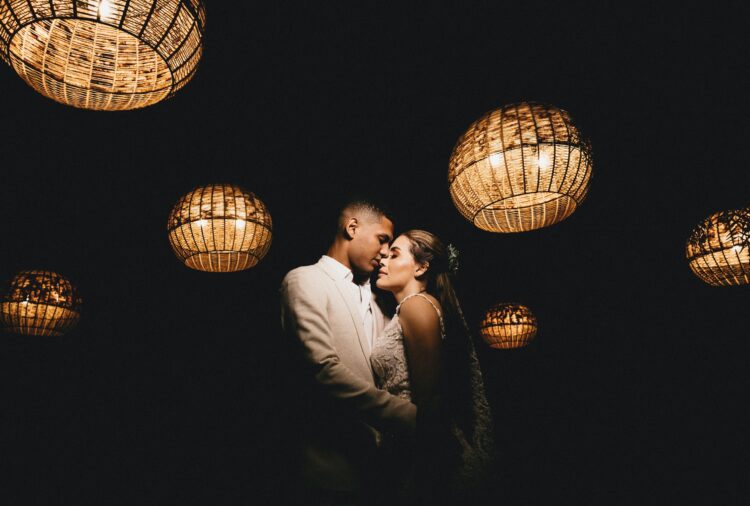 loving ethnic newlyweds hugging in dark studio