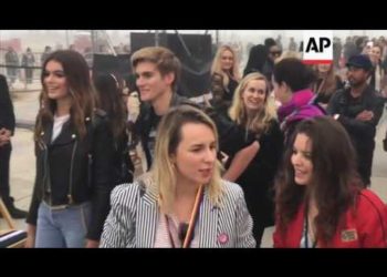 Tommy Hilfiger kneels before Lady Gaga at Venice Beach fashion show, Fergie performs