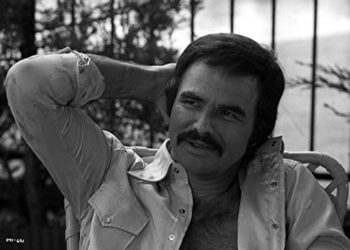 Burt Reynolds wearing an unbuttoned shirt with his hand on his head Photo Print (10 x 8)